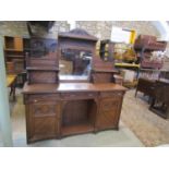 A late Victorian oak mirror-back sideboard the raised back incorporating a rectangular mirror