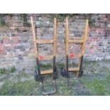 A pair of vintage heavy duty sack trucks with ashwood shafts united by square through jointed