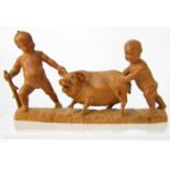 Carved oriental timber Okimono group of two boys pulling and shoving a fat porker, 16cm long