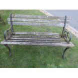 A two seat garden bench with pierced cast iron ends and weathered timber lathes (AF), 4ft wide