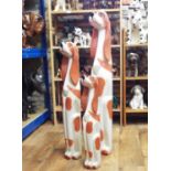Three amusing carved timber figures of stylised spaniels, 107cm max