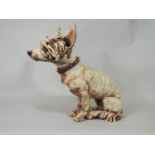 A contemporary studio ware pottery figure of a recumbent hound with spiked collar monogrammed JC, 28