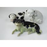A group of three Chinese/Japanese porcelain dogs, in seated or playful poses, 17cm high max