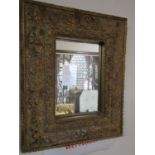 A small contemporary reproduction cushion framed wall mirror of rectangular form with scrolling