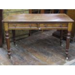 A Victorian mahogany writing/side table enclosed by two frieze drawers raised on four turned