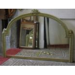 An overmantle mirror of stepped arched form, the gilt painted frame with raised flower basket,