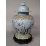 A 19th century oriental pale blue ground vase and cover with polychrome painted decoration of