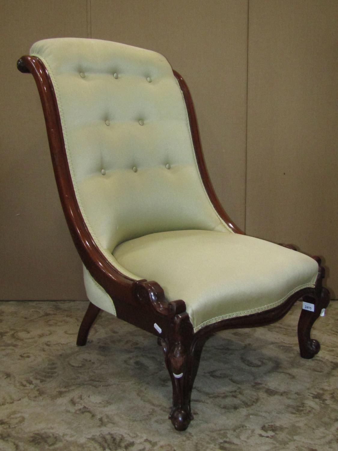 A Victorian nursing chair with serpentine upholstered seat and button back within a mahogany