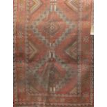 Afghan three medallion runner, with geometric decoration upon a washed red ground, 210 x 110cm (af)