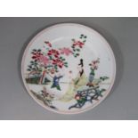 A 19th century oriental plate with polychrome painted decoration of a woman and child in landscape