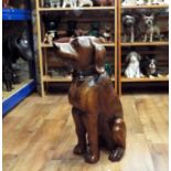 A carved hardwood figure of a seated hound, 62cm high