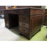 A reproduction mahogany kneehole twin pedestal desk in the Georgian style with inset green leather