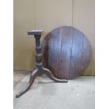 A Georgian oak snap top occasional table of circular form raised on a turned pillar and tripod,