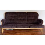 An Ercol light beechwood framed Windsor stickback three seat sofa with loose upholstered stylised