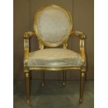 A pair of fautilles with serpentine upholstered seats and padded cameo shaped backs within gilded