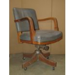 A vintage oak framed swivel office desk chair with faux leather upholstered seat and curved back