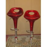 A pair of contemporary high adjustable retro style bar stools with moulded fibre glass seats,