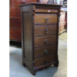 An oak pedestal chest of five long drawers with reeded detail flanked by split beadwork mouldings,