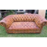 A Chesterfield sofa in mid-tan leather upholstery with overall buttoned finish, 185cm wide