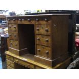 A small Victorian pitch pine kneehole desk with inset green leather writing surface over an