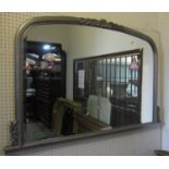 A Victorian style overmantle mirror with bevelled edge plate within a moulded arched frame with tied