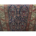 A good long Persian runner with paisley type central decoration upon a navy blue ground, with