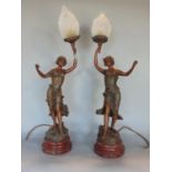 Pair of French spelter figural table lamps in the form of robed maidens holding aloft flaming opaque