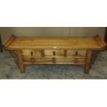 A low Chinese elm table of rectangular form, the top with scrolled ends over three frieze drawers