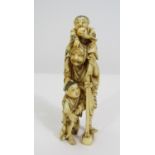 Meiji Period - Ivory Okimono of an old man with a staff, accompanied by two small boys, one with a