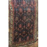 Antique Persian rug with geometric floral patterns upon a navy blue ground, 190 x 120cm