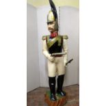 A carved timber model of a 19th century Prussian Officer, in military uniform with pistol and sword,