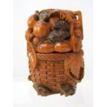 A Japanese carved box and cover in timber, of oval form, in the form of a wicker basket laden with