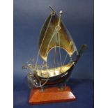 Cased white metal galleon with wooden plinth stand, 2 oz approx