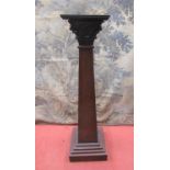 A late 19th century mahogany torchere, the pillar of square cut tapering form, beneath an ionic