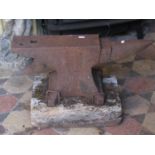 A small but heavy cast iron anvil mounted/pegged to an old wooden rectangular block (stamped), 59 cm