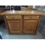 A good quality contemporary John Lewis light oak side cupboard enclosed by a pair of moulded fielded