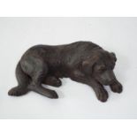 A late 19th century Tirolean carved figure of a recumbent hound, 19cm long