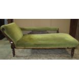An Edwardian chaise lounge with green dralon upholstered seat, scrolled back and arm pad with oak
