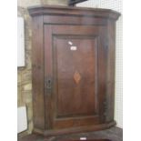 A Georgian oak country made hanging corner cupboard enclosed by a rectangular fielded panelled