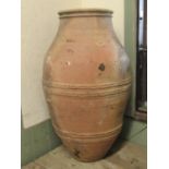 An old terracotta jar with ribbed moulded body and rim, 70 cm high