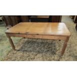 A stripped pine farmhouse kitchen table of rectangular form with segmented boarded top, moulded