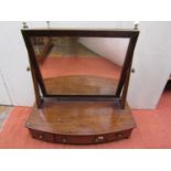 A Georgian mahogany toilet mirror, the box base with bow shaped outline and incorporating three