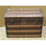 An antique timber lathe bound domed top trunk with hinged lid containing a collection of woollen