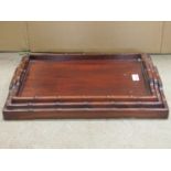 A graduated set of three Chinese hardwood tea trays of rectangular form with simulated bamboo