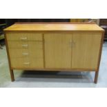 A Mann Egerton Furniture Ltd teak sideboard partially enclosed by two doors flanked by four long