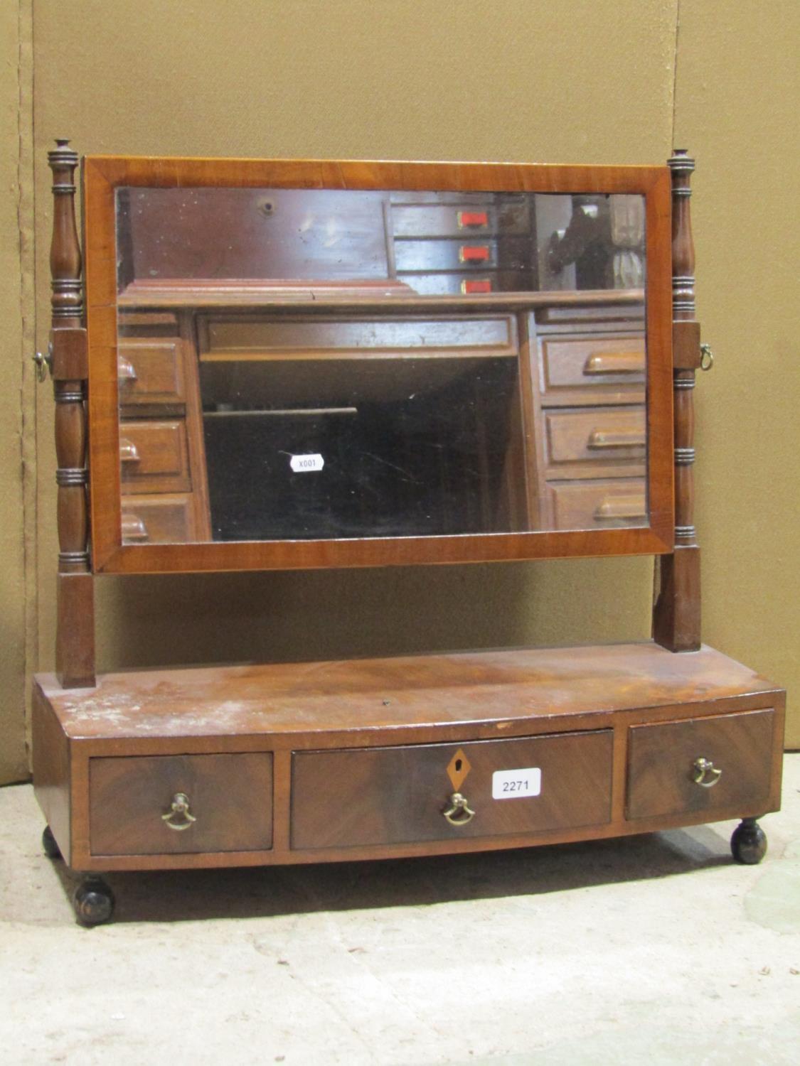 A Regency mahogany toilet mirror of rectangular form with ring turned supports and bow fronted box