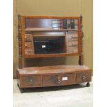 A Regency mahogany toilet mirror of rectangular form with ring turned supports and bow fronted box