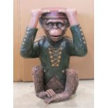 A novelty composite occasional table, the base/support in the form of a monkey wearing a green