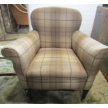 An Edwardian easy chair with rolled arms and tartan style upholstery in light brown tones raised