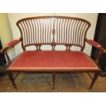 An inlaid Edwardian mahogany parlour room settee, the open framework with shaped wavy stick back,